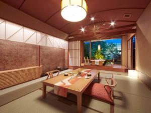 a dining room with a table and chairs and a window at Hokuriku Fukui Awara Onsen Mimatsu in Awara