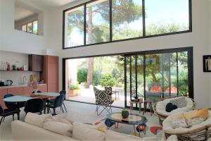 a living room with a couch and tables and windows at superb villa with private pool, with magnificent view of the luberon, in the heart of provence, 8 persons in Puget