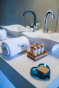 Un mostrador de baño con lavabo con toallas y una botella de medicinas. en Hotel Maresta Lodge - Hotel Asociado Casa Andina en Chimbote