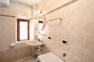 ein Badezimmer mit Waschbecken, Toilette und Spiegel in der Unterkunft Appartamenti Gg 3 in Livigno + 11 Fotos