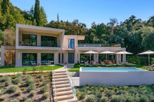 a house with a swimming pool in front of it at Villa Optima by Villa Plus in Peroúlion