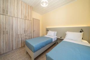 two beds in a small room with a blue bed at Villa Onera in Vlachata +25 photos