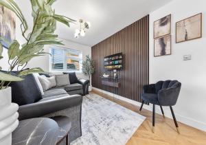 a living room with a couch and a chair at Spacious 4BR Home in Brentford Free Parking in Brentford