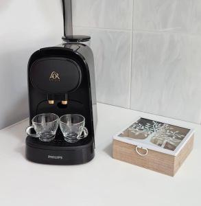 a coffee maker with two glasses and a box on a counter at Fantastic Holiday Apartment in Arona