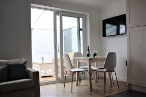 Una sala de estar con una mesa y sillas y una ventana. en Heron House, en Thrapston