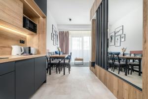 een keuken en eetkamer met tafels en stoelen bij Apartament Flaming Hanza Tower in Szczecin