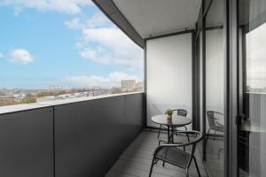 een balkon met een tafel, stoelen en een raam bij Apartament Flaming Hanza Tower in Szczecin