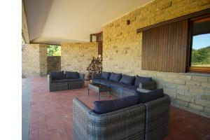 patio con divani e muro di mattoni di Villa Le Fate - tra mare e lago a Sambuco