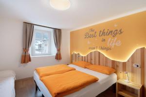 ein Schlafzimmer mit einem Bett mit einer orangefarbenen Decke in der Unterkunft Appartamenti Gg 2 in Livigno