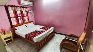 a bedroom with a bed in a pink wall at Thiru Arunesha Family Home Stay Tiruvannamalai in Tiruvannāmalai