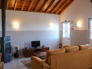 a living room with a couch and a tv at Atlantis Breeze in Madalena