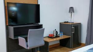 ヌアクショットにあるSabah Resort Nouakchottのテレビ、椅子、テーブルが備わる客室です。