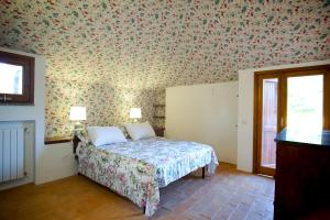 una camera da letto con un letto con carta da parati floreale di Villa Le Fate - tra mare e lago a Sambuco Altre 39 foto