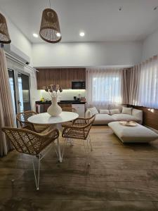 マリーニャ・グランデにあるMarinha Grande Apartamentos COCOON N10のテーブルと椅子とソファのあるリビングルーム