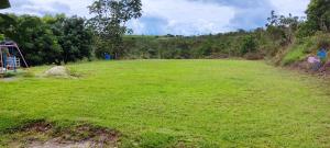 a large grass field with a rock in the middle at Chácara 2 Marias in Novo Gama