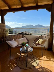 a balcony with two chairs and a table with a view at Magical Andalusian Vacation "Los Arcos" in Tózar