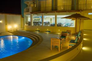 钦博特Hotel Maresta Lodge - Hotel Asociado Casa Andina的带椅子、桌子和遮阳伞的游泳池