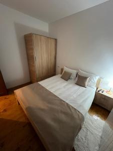 a bedroom with a large bed and a cabinet at Ruža vetrova A1- duplex in Nova Varoš