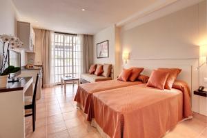 a hotel room with a large bed and a kitchen at Grupotel Club Menorca in Son Xoriguer +23 photos