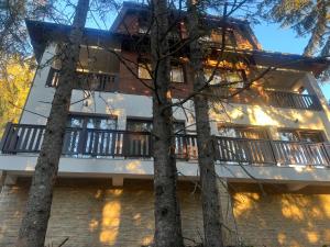 a building with a balcony and some trees at Ruža vetrova A1- duplex in Nova Varoš