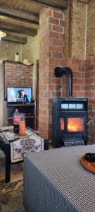 a living room with a fireplace and a stove at Planinska kuca Gogo in Kupres