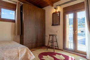 a bedroom with a bed and a window and a stool at Mareu Stonehouse in Panóramo