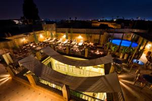 an outdoor patio with tables and chairs at night at Riad Signature in Marrakesh