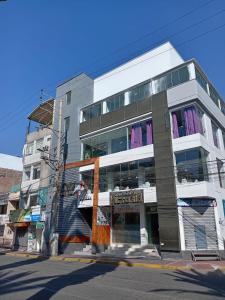 a tall white building on a city street at Gran Hotel Victoria in Tacna +50 photos