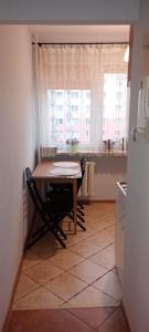 een kleine keuken met een tafel en een raam bij Apartament WARSZAWSKA in Kielce