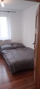 een bed in een witte slaapkamer met een raam bij Apartament WARSZAWSKA in Kielce
