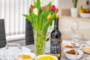 ハンティンドンにあるStylish 2 Bedroom Apartment By Your Lettings Short Lets & Serviced Accommodation Peterborough With Free WiFi,Parking And Moreのワイン1本、花瓶1本