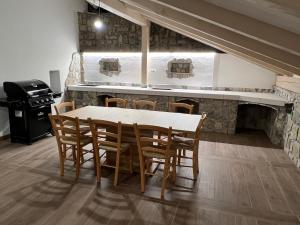 a dining room with a table and chairs and a stove at Luxury House Ledine in Spodnja Idrija