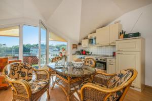 een eetkamer met een tafel en stoelen en een keuken bij Düneneck 32 in Zempin +5 foto's