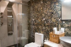 a bathroom with a shower and a toilet and a sink at Oreades Parthenon Suites in Athens +60 photos