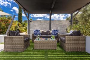 un patio avec des chaises en osier et une table sur l'herbe dans l'établissement Villa Ampelaki - Premium Villa with heated pool, à Kounoupidhianá