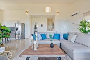 a living room with a gray couch and blue pillows at Villa Marathi with stunning ocean view in Chania Town