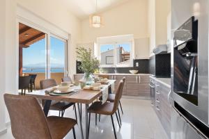 a kitchen and dining room with a table and chairs at Villa Marathi with stunning ocean view in Chania Town