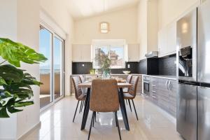 a kitchen with a dining room table and chairs at Villa Marathi with stunning ocean view in Chania Town