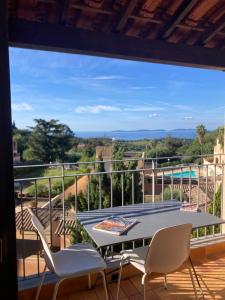 eine Terrasse mit Tisch und Stühlen auf einem Balkon in der Unterkunft Superbe appartement T1 duplex,vue mer in La Croix-Valmer