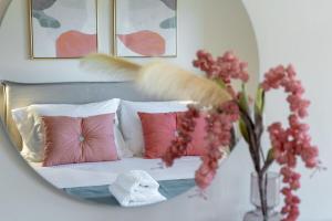 a mirror reflection of a bed with pink pillows at Villa Marathi with stunning ocean view in Chania Town