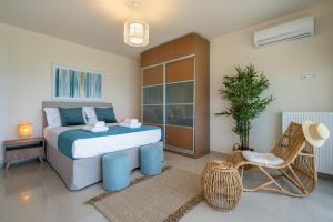 a bedroom with a bed and a chair and a plant at Villa Marathi with stunning ocean view in Chania Town