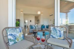 a living room with two chairs and wine glasses at Villa Marathi with stunning ocean view in Chania Town