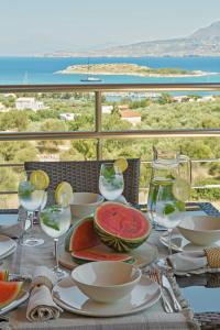 a table with wine glasses and watermelons on it at Villa Marathi with stunning ocean view in Chania Town