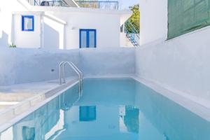 a swimming pool with blue water and a white house at Armenous Green Dia's Mansion in Arménoi