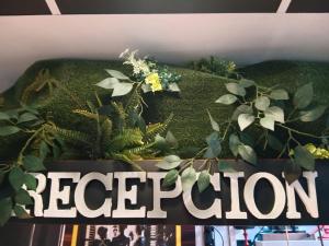a sign with a plant on top of a book at El Escondite Perfecto in Benacazón