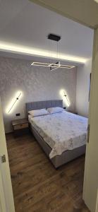 a bedroom with a bed with two lights on it at Stela in Herceg-Novi +3 photos
