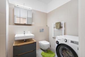 a bathroom with a sink and a washing machine at Moderný Apartmán s parkovaním v Novostavbe in Bratislava
