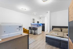 a living room with a couch and a desk at Moderný Apartmán s parkovaním v Novostavbe in Bratislava