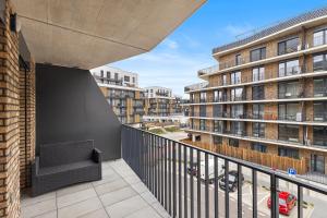 a balcony with a couch and a building at Moderný Apartmán s parkovaním v Novostavbe in Bratislava