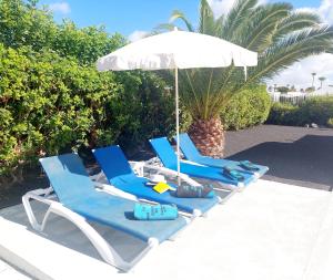 a group of blue chairs and an umbrella at Casa Jaime in Puerto del Carmen